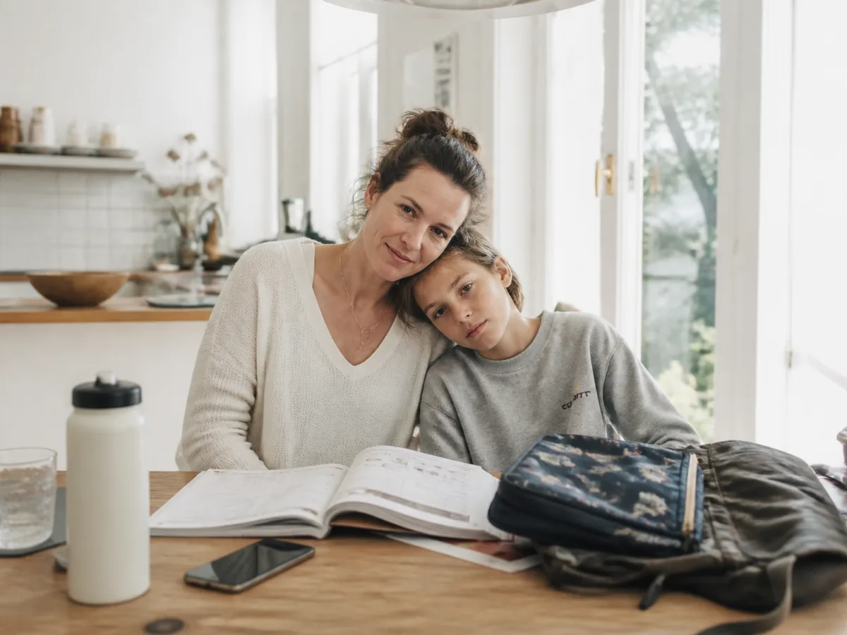 Mutter und ihr 11-jähriges Kind am Tisch nach einem vollen Schultag – Alltagsstress in Familien