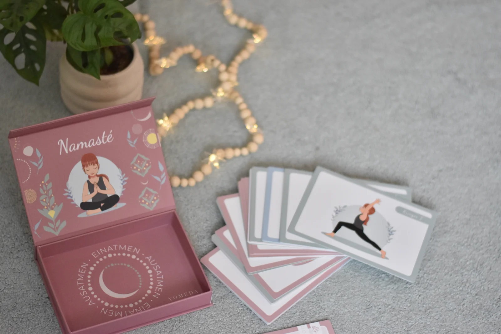 Geöffnete Yomeda Box mit aufgefächerten Yoga Bildkarten von oben fotografiert